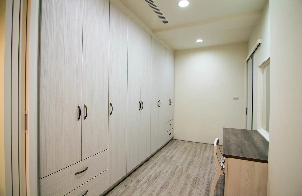 台南新成屋室內設計：客製化更衣室系統櫃，搭配內嵌燈帶與木質配色，打造高品質收納空間。