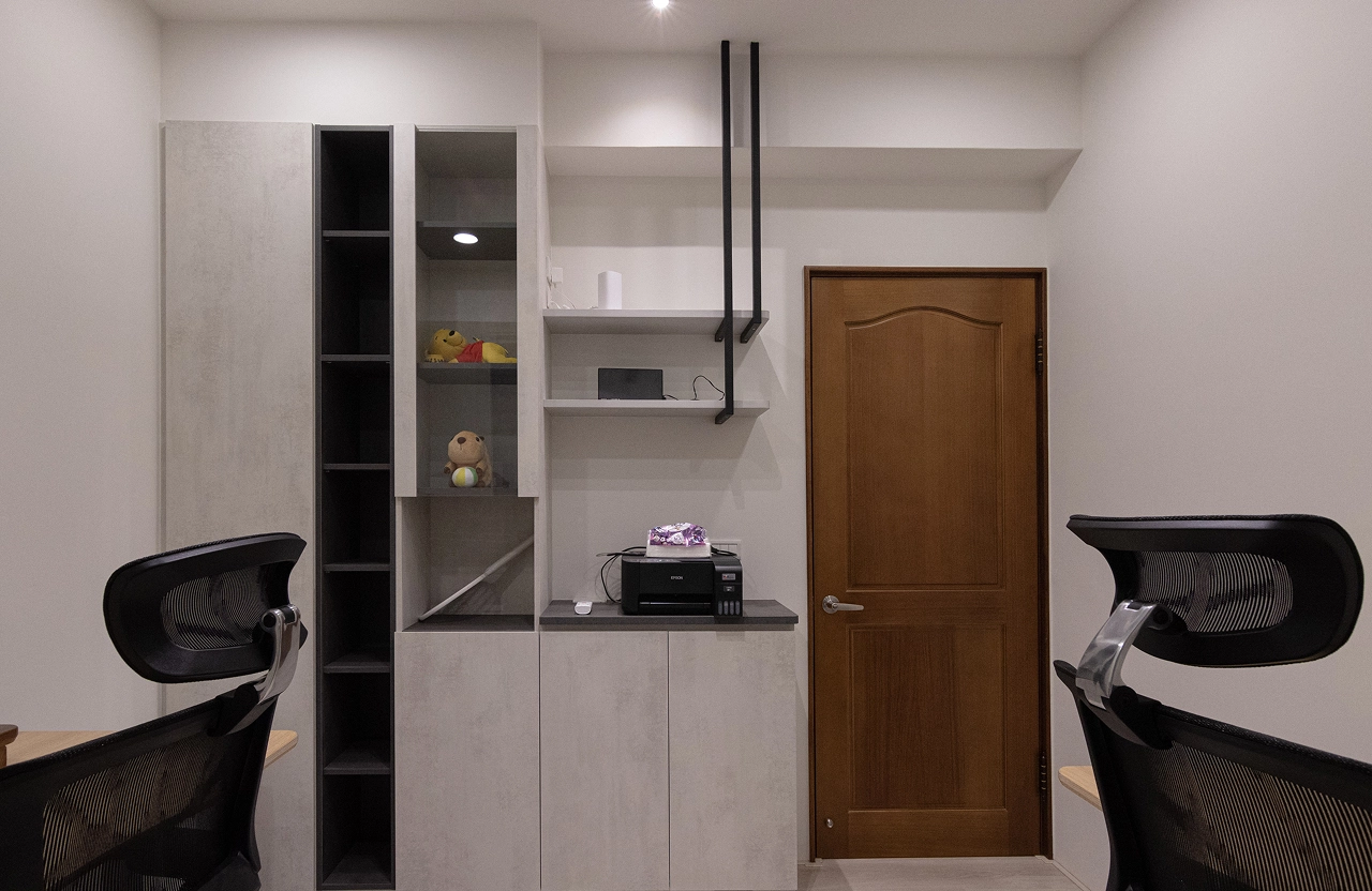 簡約風書房設計採用開放式系統書櫃，搭配黑色造型鐵件吊架與系統桌面，打造具現代感的居家辦公與收納空間。