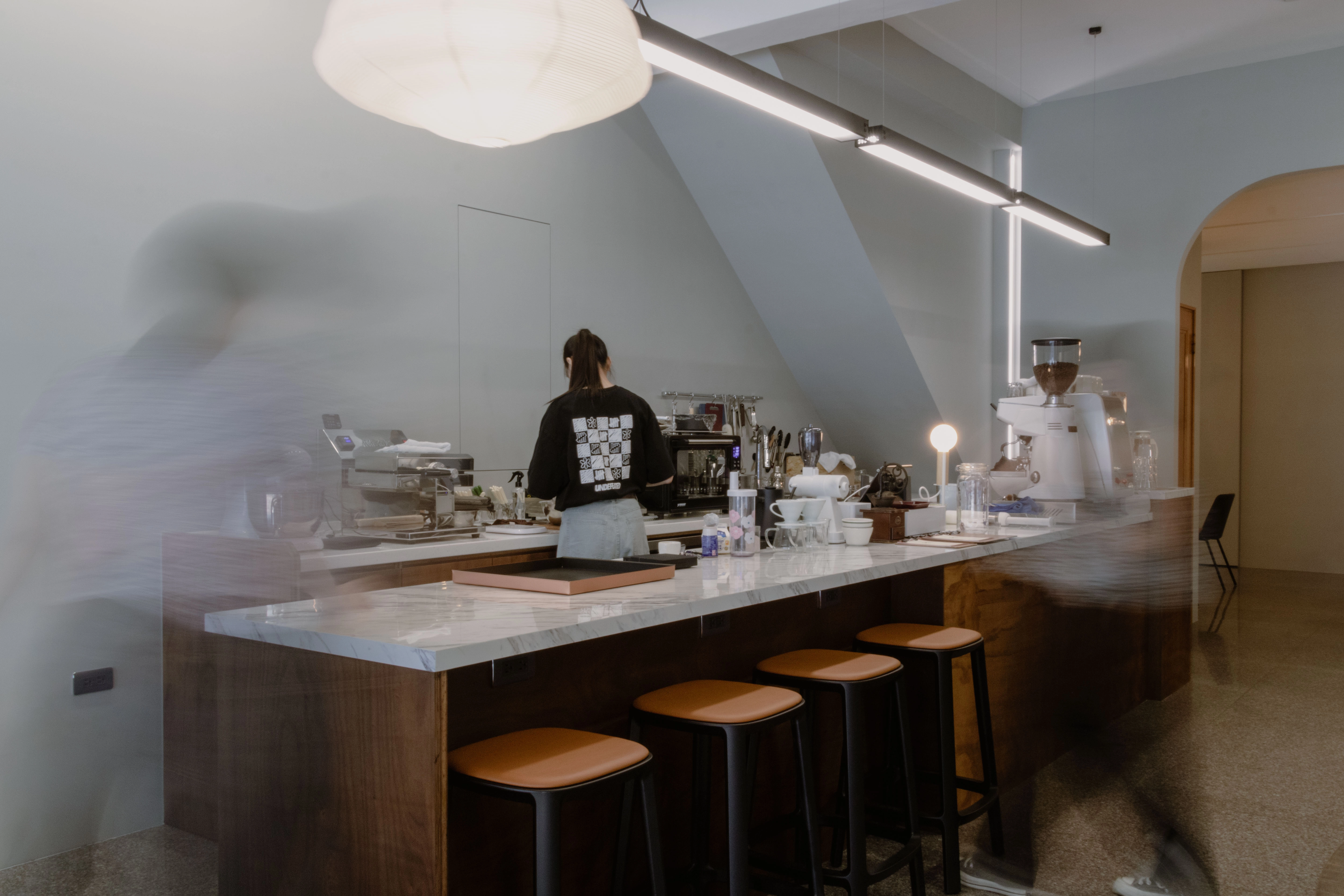 德盈設計咖啡廳商空:質感石紋吧台搭配柔和間接光源,營造極具品味的現代文青風格。