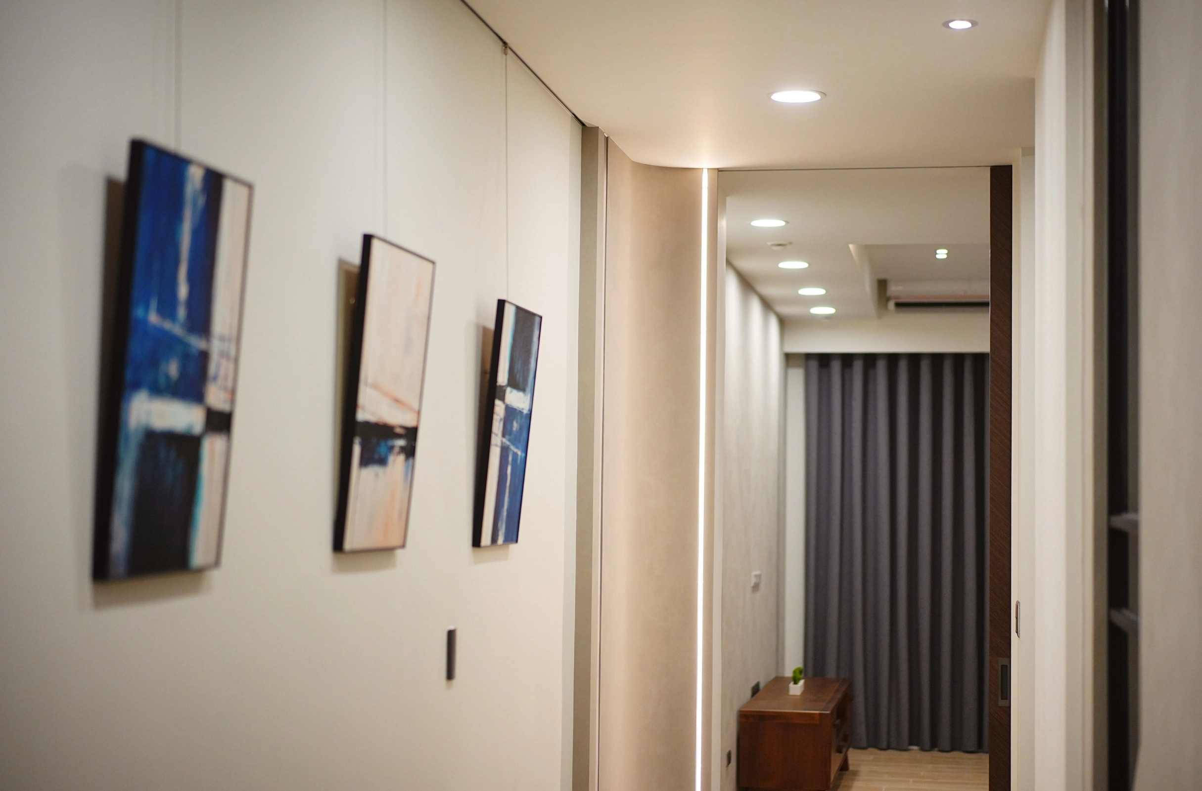 德盈室內設計:走廊採用溫潤木質材質,輔以柔和間接光線,營造出寧靜且具備質感的居家氛圍。