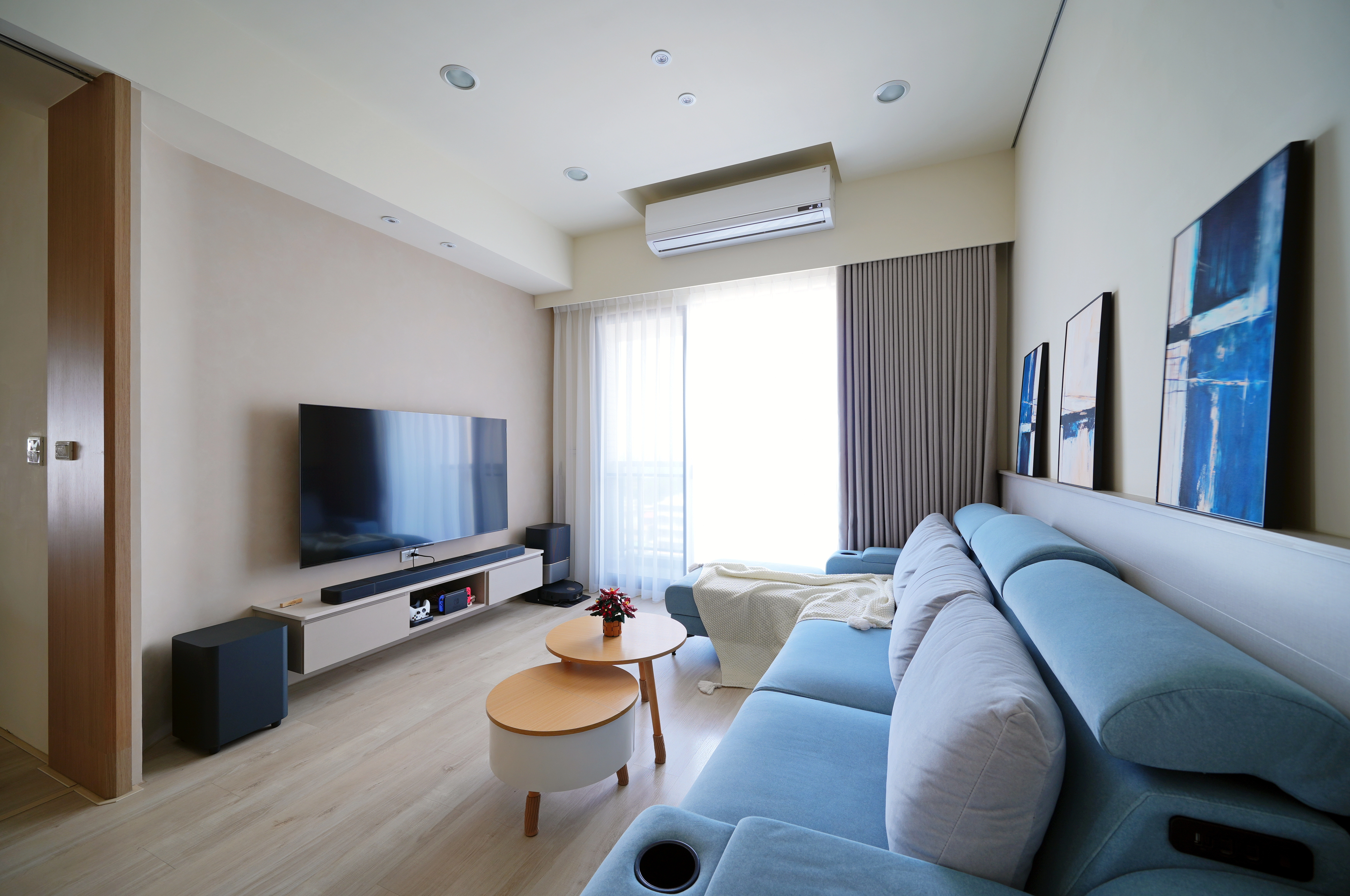 德盈設計客廳配置:懸吊電視櫃整合掃地機器人收納,展現極簡現代風空間美學。