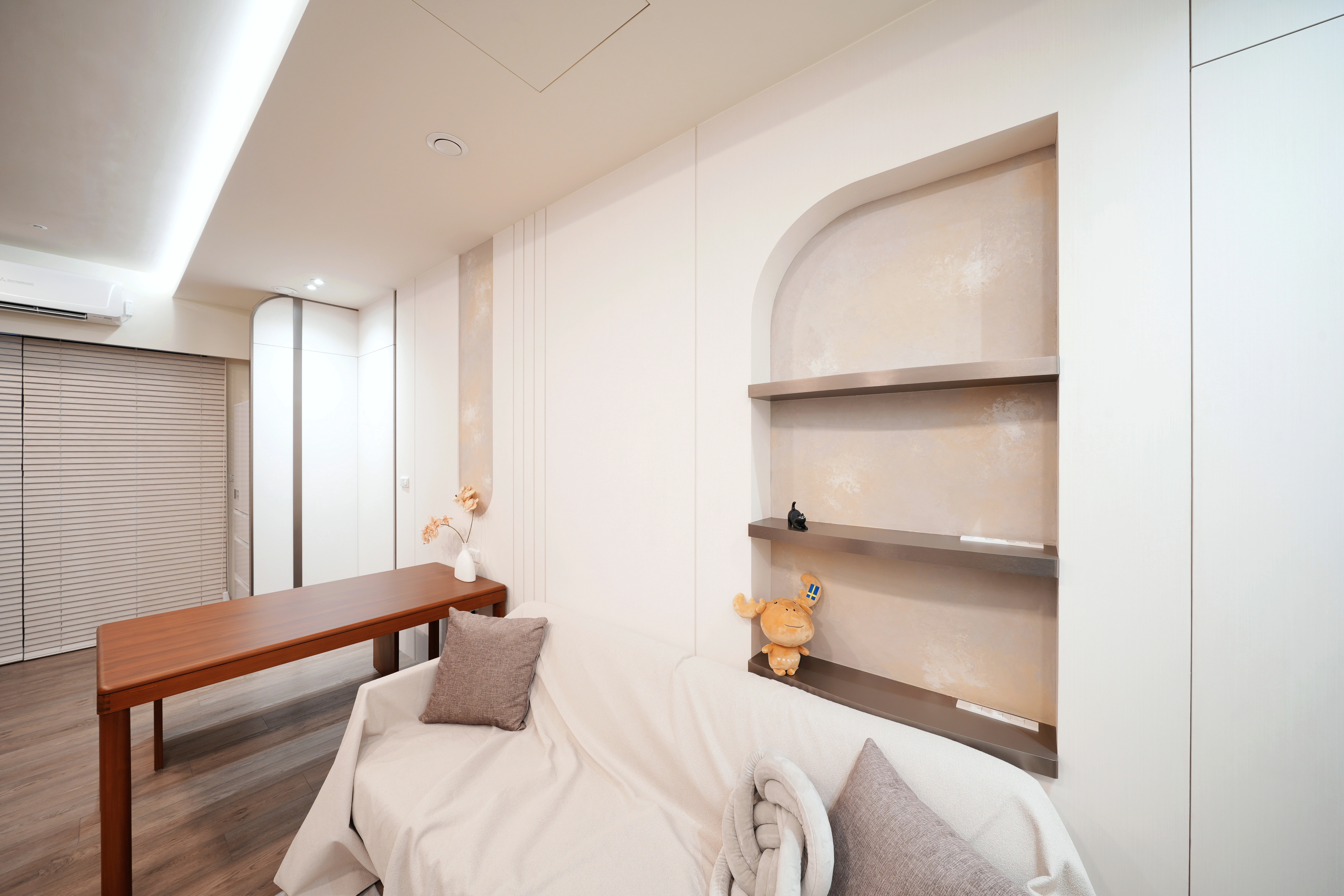 德盈室內設計:沙發背牆藝術塗料搭配弧形展示櫃,打造暖調奶咖風格。