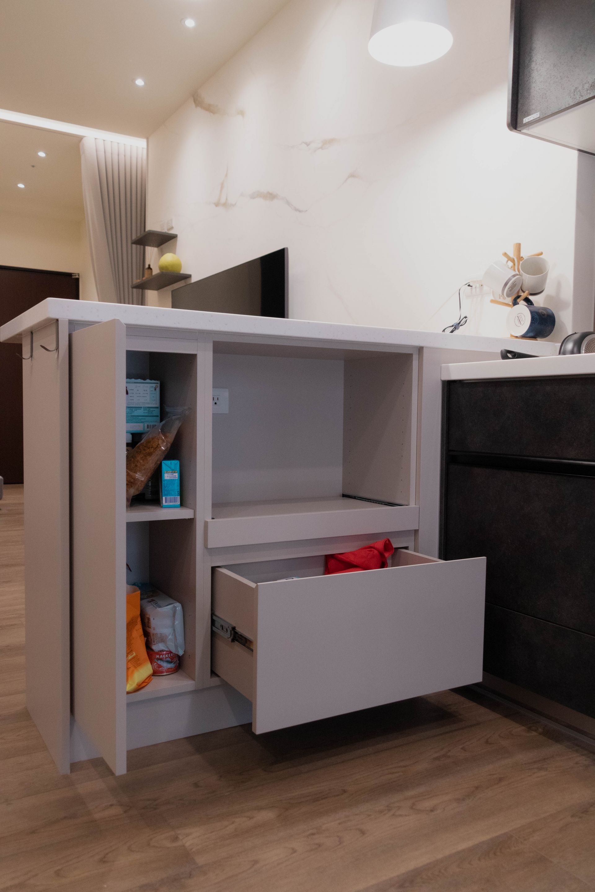 餐廚互動核心： 人造石吧檯與系統餐邊櫃，整合備餐收納，增進家人緊密互動。